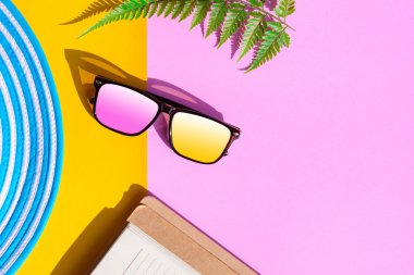 Mavi şapka ve güneş gözlüğü renkli kağıt üzerinde