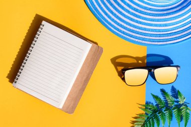 Mavi şapka ve güneş gözlüğü renkli kağıt üzerinde