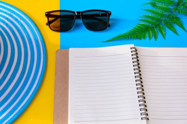 Mavi şapka ve güneş gözlüğü renkli kağıt üzerinde