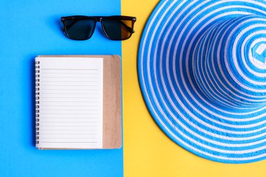 Mavi şapka ve güneş gözlüğü renkli kağıt üzerinde