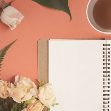 Düz yatıyordu defter ve gül kırmızı bir masa üzerine yerleştirilen