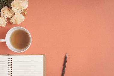 Düz yatıyordu defter ve gül kırmızı bir masa üzerine yerleştirilen