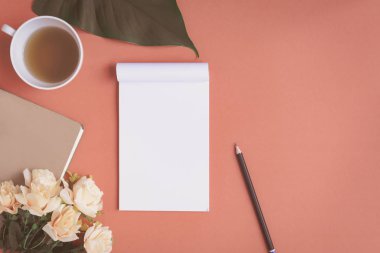 Düz yatıyordu defter ve gül kırmızı bir masa üzerine yerleştirilen