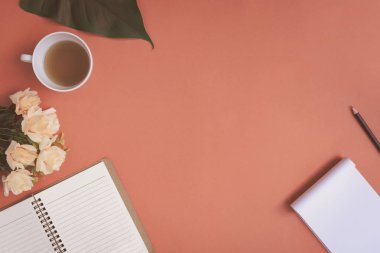 Düz yatıyordu defter ve gül kırmızı bir masa üzerine yerleştirilen