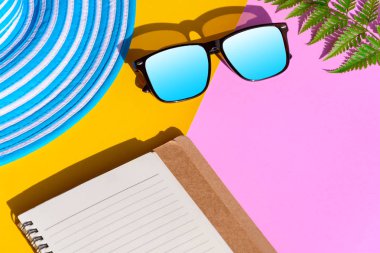 Mavi şapka ve güneş gözlüğü renkli kağıt üzerinde