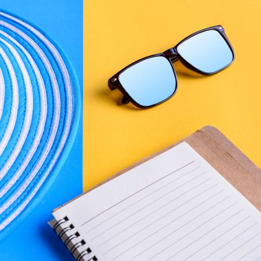 Mavi şapka ve güneş gözlüğü renkli kağıt üzerinde