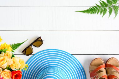 Mavi şapka güneş gözlüğü ve ayakkabı Beyaz ahşap masa üzerinde