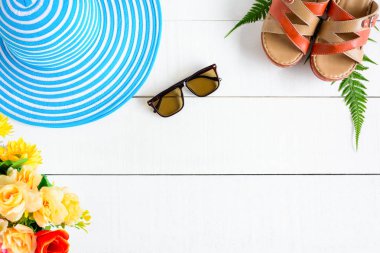 Mavi şapka güneş gözlüğü ve ayakkabı Beyaz ahşap masa üzerinde