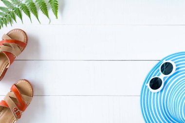 Mavi şapka güneş gözlüğü ve ayakkabı Beyaz ahşap masa üzerinde