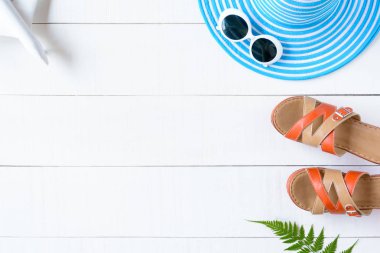 Mavi şapka güneş gözlüğü ve ayakkabı Beyaz ahşap masa üzerinde