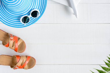 Mavi şapka güneş gözlüğü ve ayakkabı Beyaz ahşap masa üzerinde