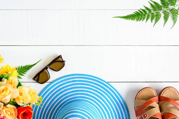 Mavi şapka güneş gözlüğü ve ayakkabı Beyaz ahşap masa üzerinde