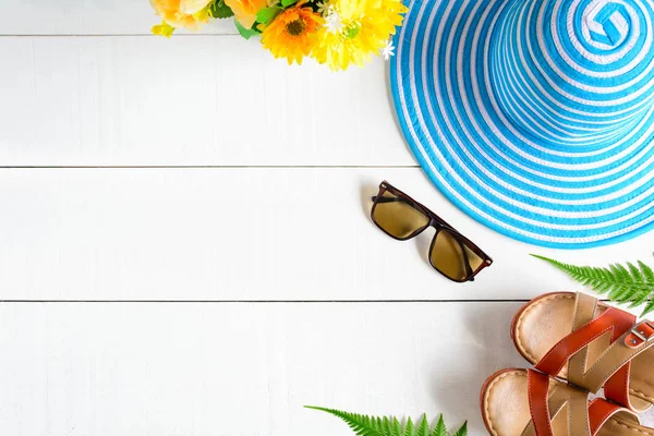 Mavi şapka güneş gözlüğü ve ayakkabı Beyaz ahşap masa üzerinde