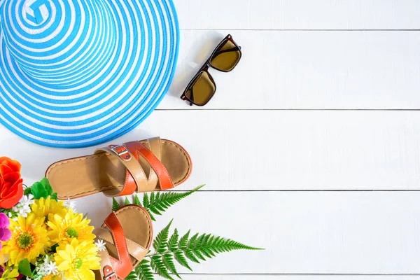 Mavi şapka güneş gözlüğü ve ayakkabı Beyaz ahşap masa üzerinde