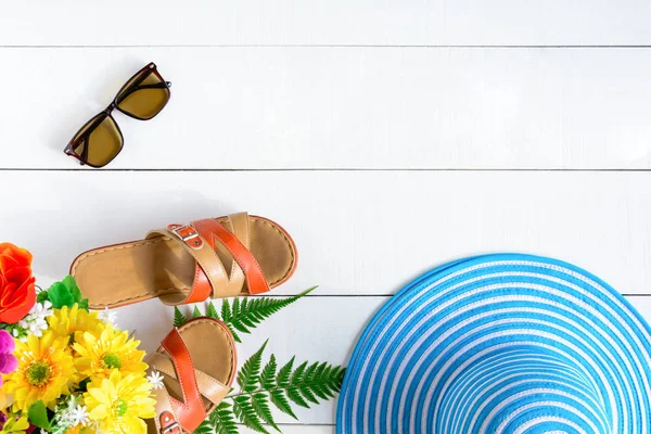 Mavi şapka güneş gözlüğü ve ayakkabı Beyaz ahşap masa üzerinde