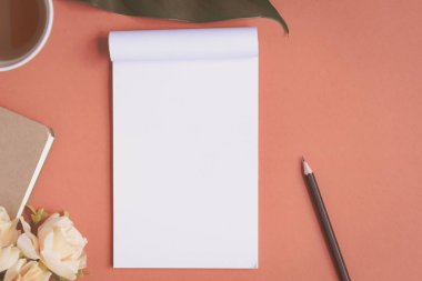 Düz yatıyordu defter ve gül kırmızı bir masa üzerine yerleştirilen