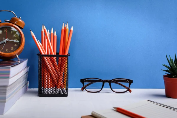 Kitap kalem ve Beyaz ahşap bir masa üzerinde gözlük vardır saatleri ve 