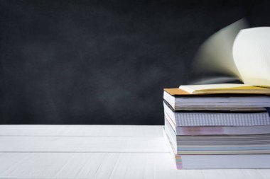 Beyaz masa kara tahta arka plan üzerinde kitap