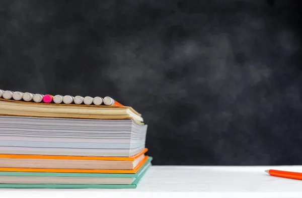 Boek en potlood op wit zwarte bord de tabelachtergrond met studeren — Stockfoto