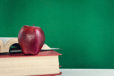 Kalem ve apple bir beyaz tahta masada kitaplar