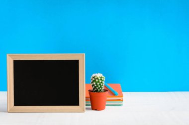 Ahşap masa üzerinde çerçeve ve kitap kalem kadar sahte ile yazı tahtası