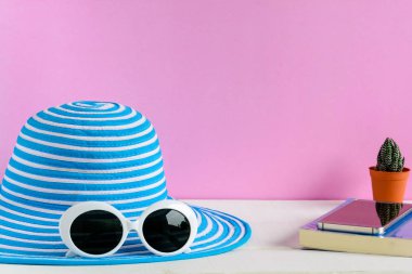 Mavi şapka ve beyaz güneş gözlüğü pembe duvar arka plan