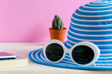 Mavi şapka ve beyaz güneş gözlüğü pembe duvar arka plan