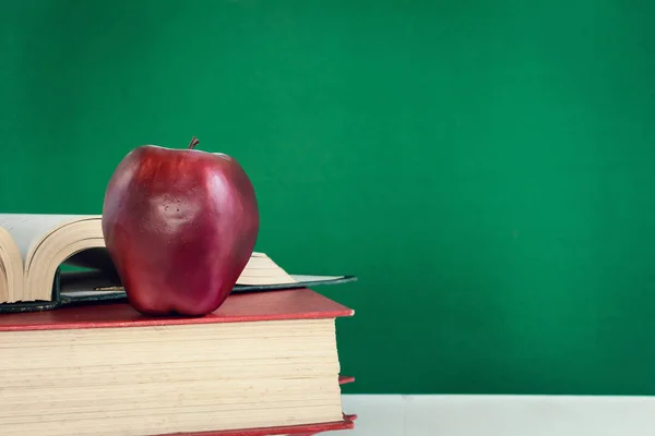 Книги Олівець і яблуко на білому дерев'яному столі — стокове фото