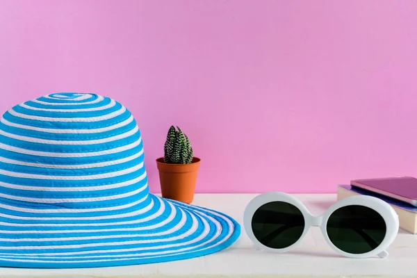 Mavi şapka ve beyaz güneş gözlüğü pembe duvar arka plan