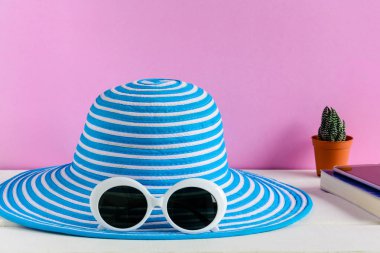 Mavi şapka ve beyaz güneş gözlüğü pembe duvar arka plan