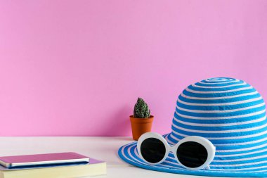 Mavi şapka ve beyaz güneş gözlüğü pembe duvar arka plan