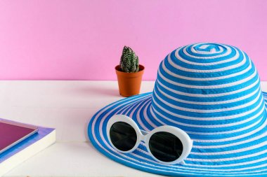 Mavi şapka ve beyaz güneş gözlüğü pembe duvar arka plan