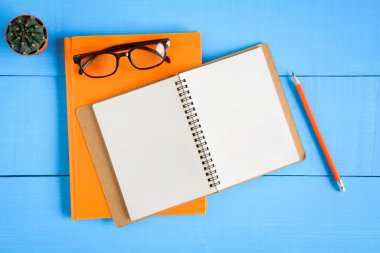 Üstten Görünüm kitap mockup ve kalem kayda göre mavi ahşap masa