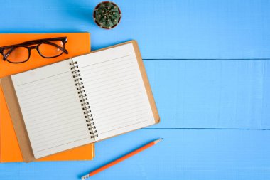 Üstten Görünüm kitap mockup ve kalem kayda göre mavi ahşap masa