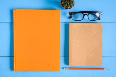 Üstten Görünüm kitap mockup ve kalem kayda göre mavi ahşap masa