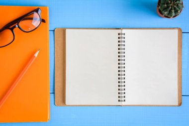 Üstten Görünüm kitap mockup ve kalem kayda göre mavi ahşap masa