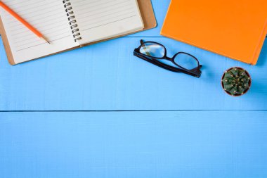 Üstten Görünüm kitap mockup ve kalem kayda göre mavi ahşap masa