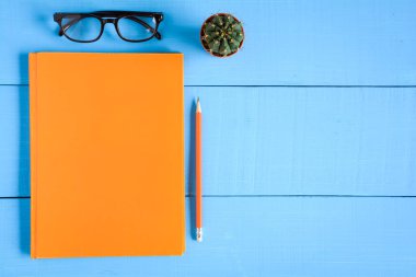 Üstten Görünüm kitap mockup ve kalem kayda göre mavi ahşap masa