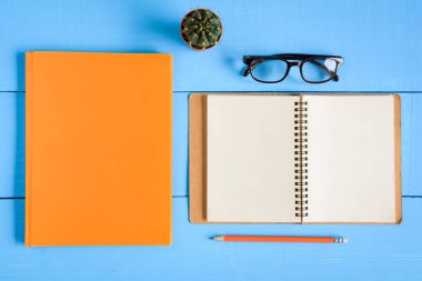 Üstten Görünüm kitap mockup ve kalem kayda göre mavi ahşap masa