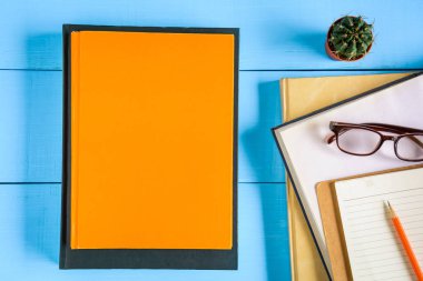 Üstten Görünüm kitap mockup ve kalem kayda göre mavi ahşap masa