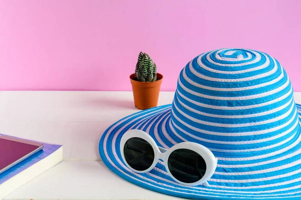 Mavi şapka ve beyaz güneş gözlüğü pembe duvar arka plan