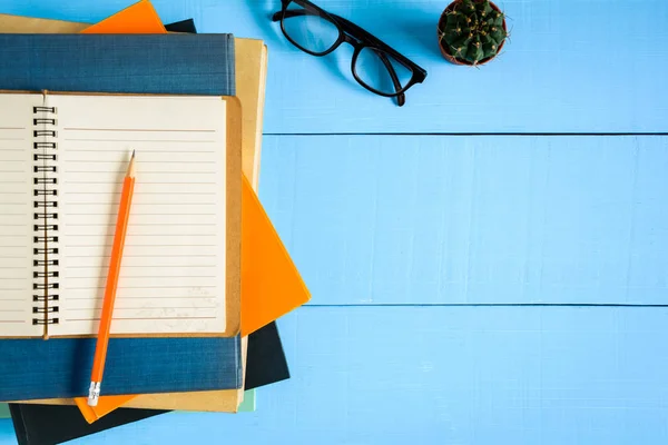 Ovanifrån bok mockup och pennan Obs på blå trä bord — Stockfoto