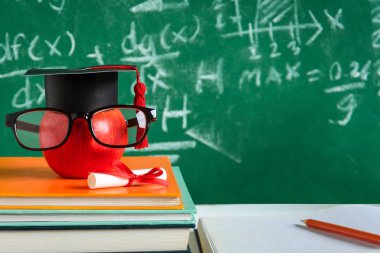 Elma bilgi sembolü ve masanın üstüne kalem kitap