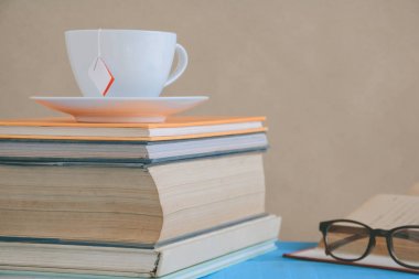 Kitap gözlük ve çay ile çalışma ve eğitim concep masaya