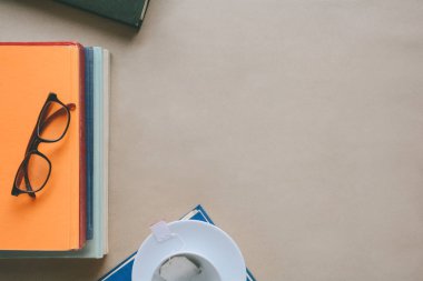 Kitap gözlük ve çay ile çalışma ve eğitim concep masaya