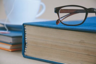 Kitap gözlük ve çay ile çalışma ve eğitim concep masaya