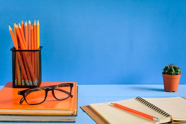 Boeken potlood en glazen op een blauwe houten tafel — Stockfoto