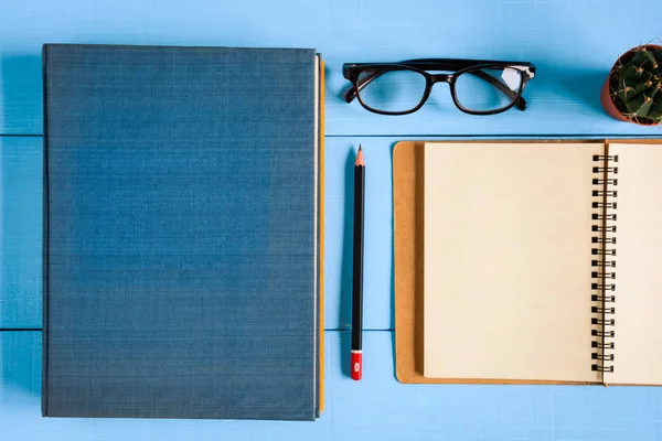 Ovanifrån bok mockup och pennan Obs på blå trä bord — Stockfoto