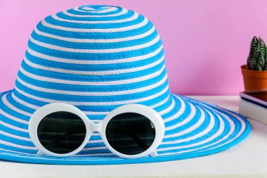 Mavi şapka ve beyaz güneş gözlüğü pembe duvar arka plan