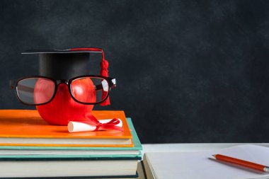 Elma bilgi sembolü ve masanın üstüne kalem kitap